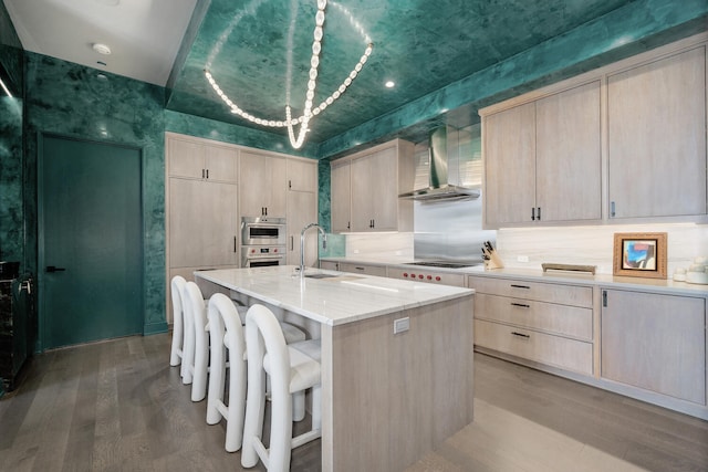 1550 N Clark St Unit 302, Chicago, IL 60610 - kitchen with wall chimney range hood, light brown cabinets, light wood finished floors, and recessed lighting