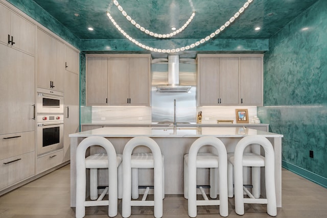 1550 N Clark St Unit 302, Chicago, IL 60610 - kitchen with extractor fan, light brown cabinets, light countertops, light wood-type flooring, and wallpapered walls