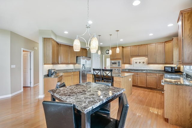 40 Open Pkwy N, Hawthorn Woods, IL 60047 - kitchen with appliances with stainless steel finishes, a kitchen island, light wood-style flooring, dark stone countertops, and recessed lighting
