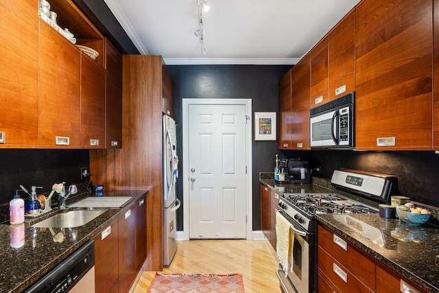2950 W Cortland St Unit 2, Chicago, IL 60647 - kitchen featuring appliances with stainless steel finishes, light wood finished floors, ornamental molding, rail lighting, and dark stone countertops