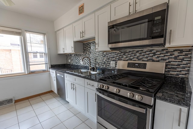 7356 N Nora Ave, Niles, IL 60714 - kitchen featuring stainless steel appliances, white cabinetry, tasteful backsplash, and dark stone countertops