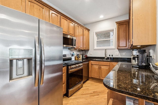 3041 N California Ave Unit 1, Chicago, IL 60618 - kitchen with stainless steel appliances, light wood-style flooring, brown cabinetry, recessed lighting, and dark stone countertops