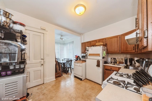 1328 W Nelson St, Chicago, IL 60657 - kitchen with white appliances, brown cabinets, light countertops, decorative backsplash, and under cabinet range hood