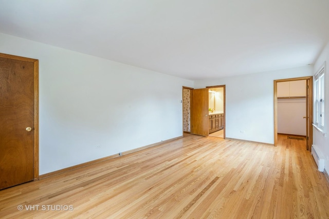 214 S Belmont Ave, Arlington Heights, IL 60005 - unfurnished bedroom with a baseboard heating unit, light wood-style floors, ensuite bathroom, and a spacious closet