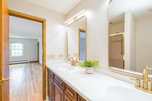 214 S Belmont Ave, Arlington Heights, IL 60005 - bathroom featuring baseboard heating, wood finished floors, double vanity, and a shower with door