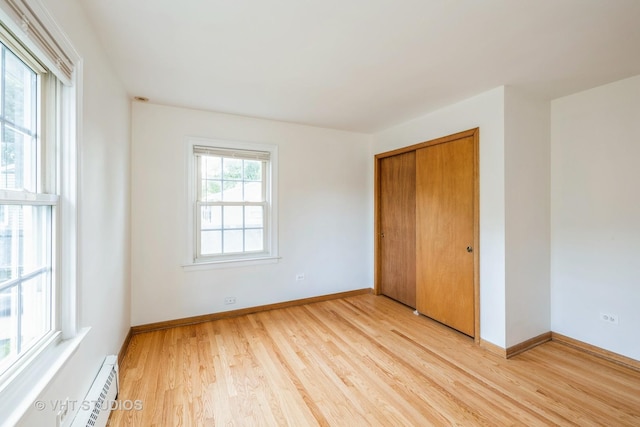 214 S Belmont Ave, Arlington Heights, IL 60005 - unfurnished bedroom featuring a baseboard radiator, light wood finished floors, and a closet