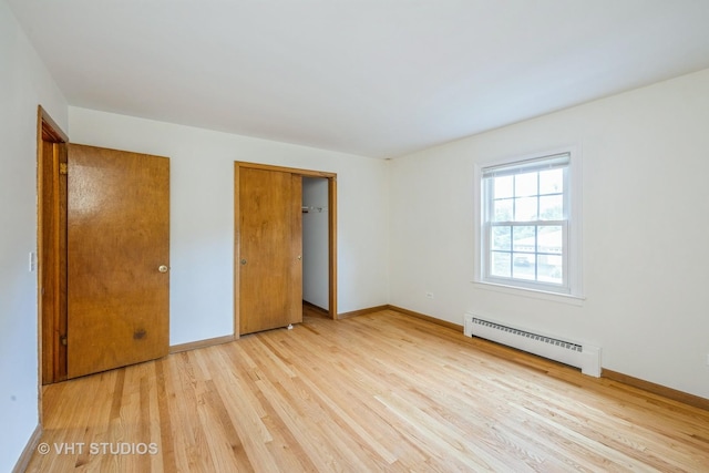 214 S Belmont Ave, Arlington Heights, IL 60005 - unfurnished bedroom with a baseboard heating unit, light wood-style floors, and a closet