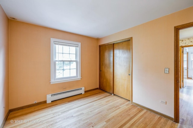 214 S Belmont Ave, Arlington Heights, IL 60005 - unfurnished bedroom with a baseboard heating unit, light wood-type flooring, and a closet