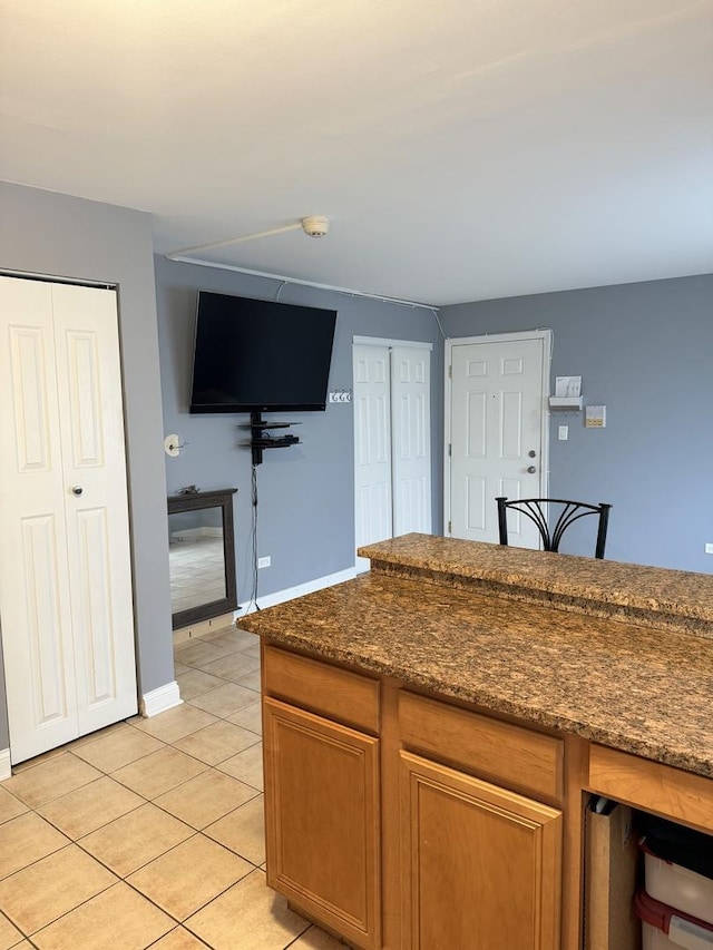 4620 Fishermans Ter Unit Ge, Lyons, IL 60534 - kitchen with light tile patterned floors, brown cabinetry, and dark stone counters