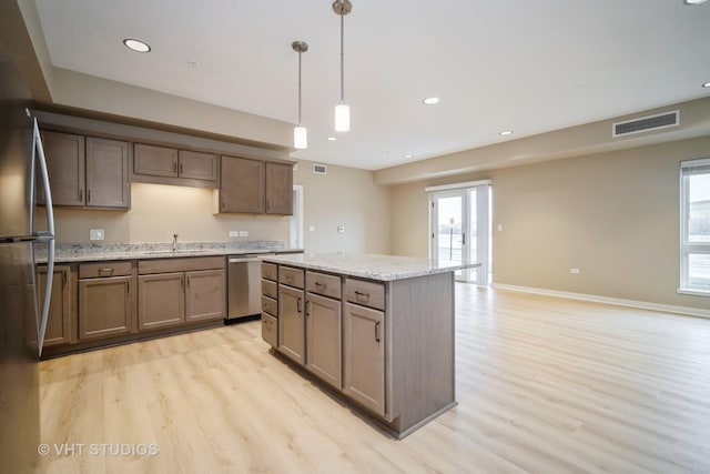 2150 Founders Dr Unit P109, Northbrook, IL 60062 - kitchen featuring stainless steel appliances, light wood-type flooring, a center island, decorative light fixtures, and recessed lighting