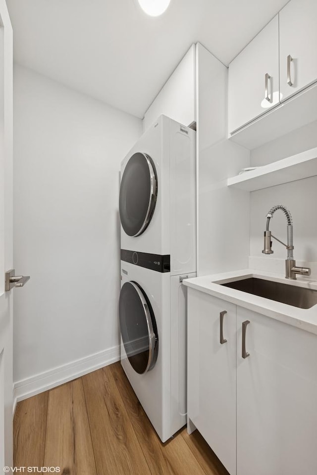1140 Old Mill Rd Unit 505F, Hinsdale, IL 60521 - washroom with stacked washer / drying machine, cabinet space, and light wood-style floors