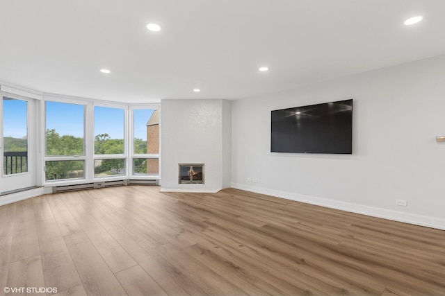 1140 Old Mill Rd Unit 505F, Hinsdale, IL 60521 - unfurnished living room featuring wood finished floors, recessed lighting, a glass covered fireplace, and a baseboard heating unit