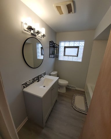 605 Hoxie Ave, Calumet City, IL 60409 - full bathroom featuring vanity, wood finished floors, and a bath