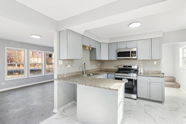 17304 Lathrop Ave, East Hazel Crest, IL 60429 - kitchen featuring gas stove, gray cabinets, light stone countertops, light marble finish floors, and a peninsula