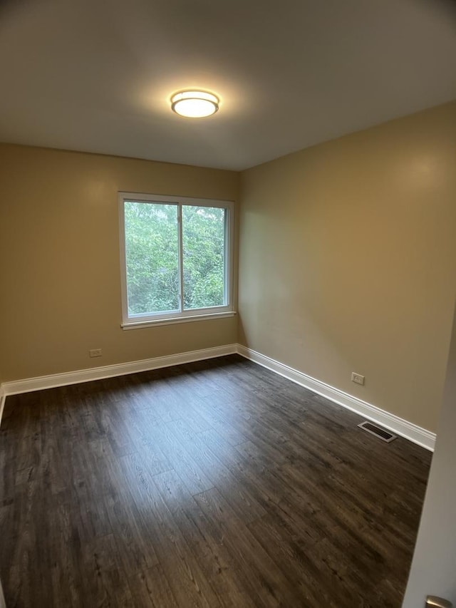 1318 Kingsbury Dr Unit 1, Hanover Park, IL 60133 - spare room featuring dark wood-style floors and baseboards
