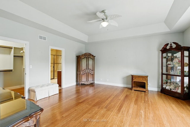 15701 Cove Cir, Plainfield, IL 60544 - unfurnished living room with a tray ceiling, a ceiling fan, and light wood-style floors