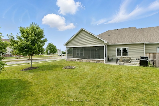 15701 Cove Cir, Plainfield, IL 60544 - rear view of house featuring a sunroom, a patio, an outdoor fire pit, and a shingled roof