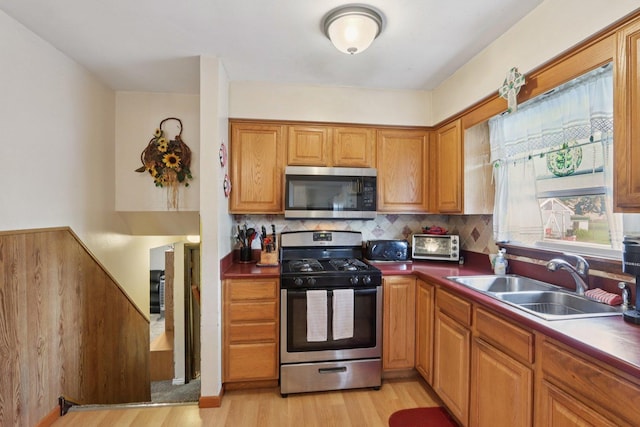 10956 S Nagle Ave, Worth, IL 60482 - kitchen featuring appliances with stainless steel finishes, light wood-style floors, tasteful backsplash, and brown cabinetry