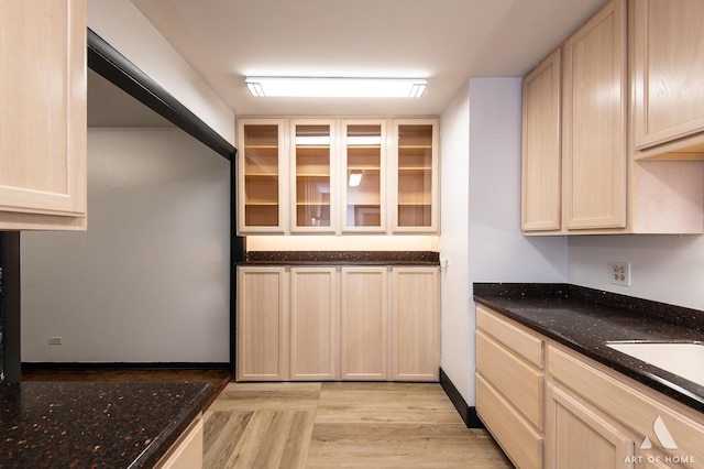 101 N Peartree Ln Unit 101, Arlington Heights, IL 60004 - kitchen with dark stone countertops, light wood finished floors, glass insert cabinets, and light brown cabinetry