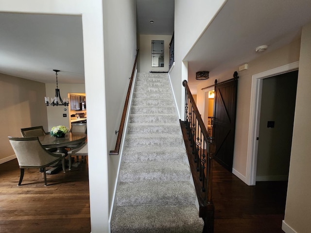 723 Casey Dr, Minooka, IL 60447 - stairs featuring wood finished floors, a barn door, and a chandelier