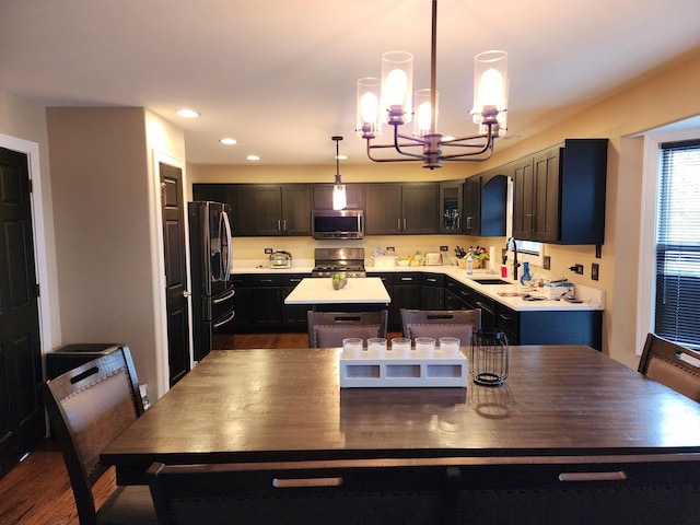 723 Casey Dr, Minooka, IL 60447 - kitchen featuring appliances with stainless steel finishes, a chandelier, a center island, light countertops, and dark wood-type flooring