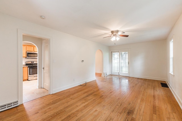 310 Virgil St, Maple Park, IL 60151 - spare room featuring arched walkways, ceiling fan, healthy amount of natural light, and light wood-style flooring