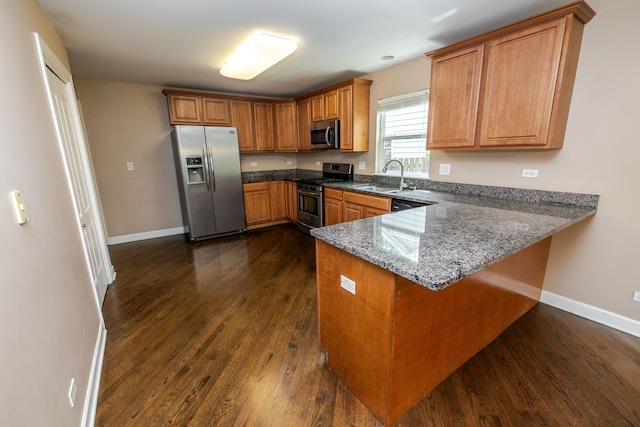 340 Hubbard Ave, Elgin, IL 60123 - kitchen featuring stainless steel appliances, brown cabinets, dark wood finished floors, a peninsula, and stone countertops