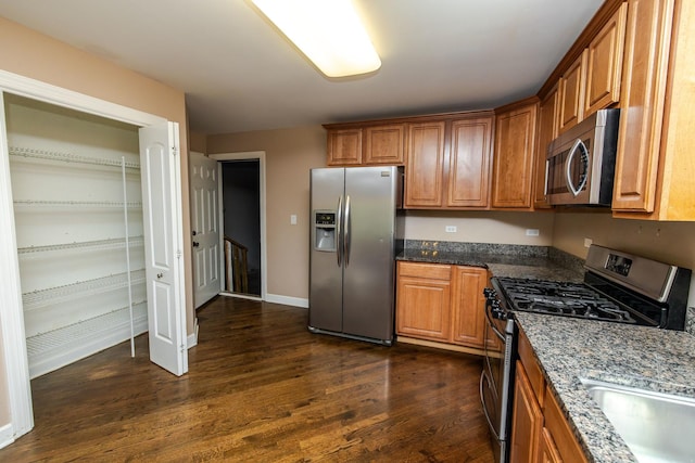 340 Hubbard Ave, Elgin, IL 60123 - kitchen with appliances with stainless steel finishes, dark wood-style flooring, brown cabinets, and dark stone counters