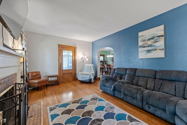 808 Glenwood Ave, Joliet, IL 60435 - living area featuring arched walkways, wood finished floors, a fireplace, and a chandelier