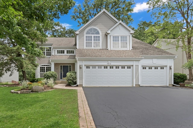 7612 Cascade Way, Gurnee, IL 60031 - traditional-style home with asphalt driveway, a shingled roof, a front lawn, and an attached garage