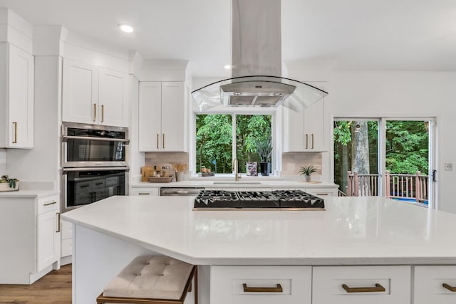 7612 Cascade Way, Gurnee, IL 60031 - kitchen with gas cooktop, island range hood, stainless steel double oven, a center island, and light countertops