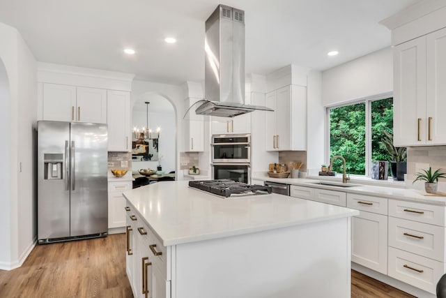 7612 Cascade Way, Gurnee, IL 60031 - kitchen featuring appliances with stainless steel finishes, island exhaust hood, a center island, arched walkways, and decorative backsplash