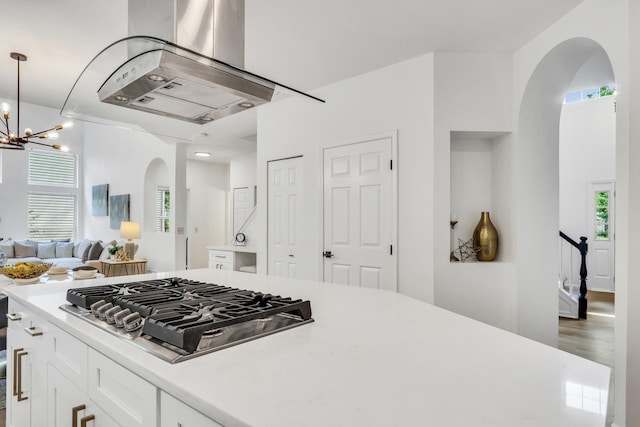 7612 Cascade Way, Gurnee, IL 60031 - kitchen with arched walkways, stainless steel gas stovetop, island exhaust hood, light countertops, and open floor plan