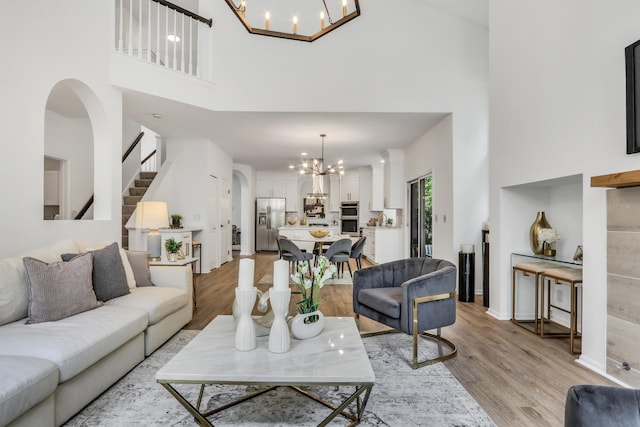 7612 Cascade Way, Gurnee, IL 60031 - living area with a chandelier, a towering ceiling, light wood finished floors, stairs, and arched walkways