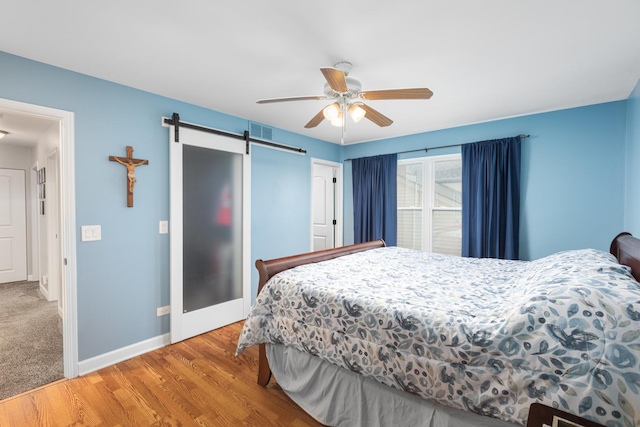 1792 Autumn Woods Ln, Romeoville, IL 60446 - bedroom with a barn door, wood finished floors, and ceiling fan