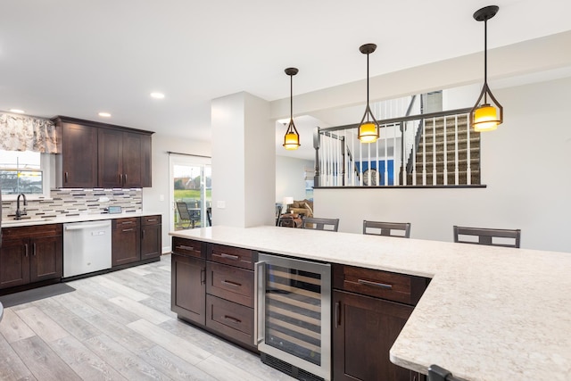 1792 Autumn Woods Ln, Romeoville, IL 60446 - kitchen with beverage cooler, stainless steel dishwasher, light countertops, light wood finished floors, and recessed lighting