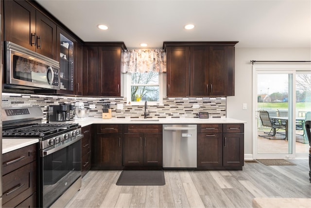 1792 Autumn Woods Ln, Romeoville, IL 60446 - kitchen with appliances with stainless steel finishes, light countertops, light wood finished floors, decorative backsplash, and healthy amount of natural light