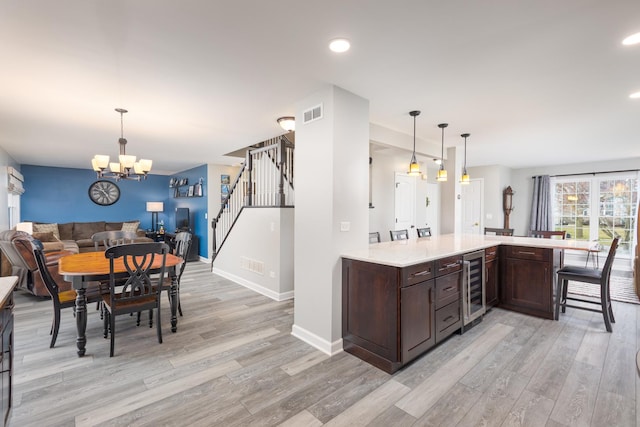 1792 Autumn Woods Ln, Romeoville, IL 60446 - kitchen featuring open floor plan, light wood-style floors, dark brown cabinets, beverage cooler, and a chandelier