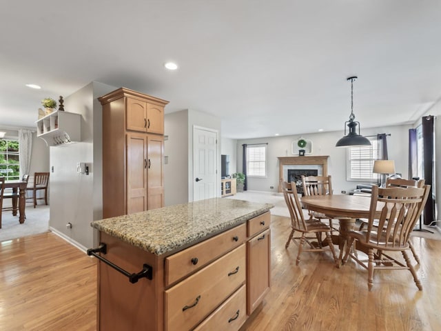 569 Ryan Way, Crystal Lake, IL 60012 - kitchen featuring a fireplace, healthy amount of natural light, light wood-style floors, recessed lighting, and light stone counters