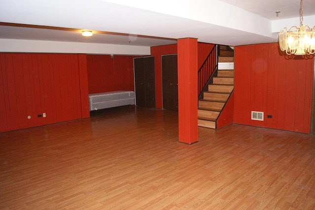 4184 Cove Ln Unit D, Glenview, IL 60025 - finished below grade area with wood finished floors, stairway, a chandelier, and wooden walls