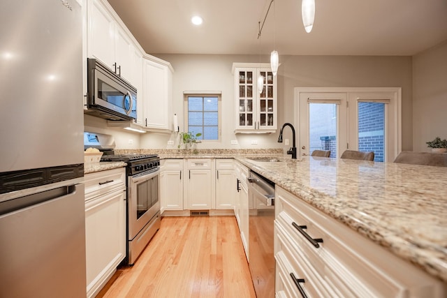 3457 N Whipple St, Chicago, IL 60618 - kitchen featuring stainless steel appliances, light wood-style flooring, white cabinetry, healthy amount of natural light, and recessed lighting