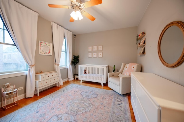 3457 N Whipple St, Chicago, IL 60618 - bedroom featuring a crib, multiple windows, wood finished floors, and radiator heating unit