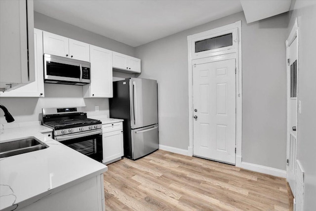 4336 W Adams St, Chicago, IL 60624 - kitchen with appliances with stainless steel finishes, white cabinetry, light wood-style flooring, and light stone counters