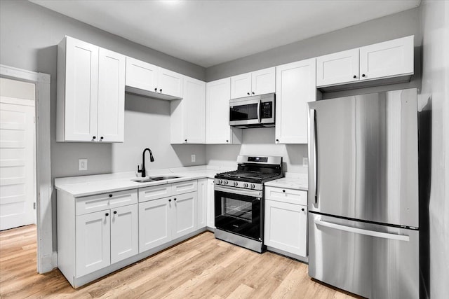 4336 W Adams St, Chicago, IL 60624 - kitchen featuring stainless steel appliances, white cabinets, and light wood-type flooring