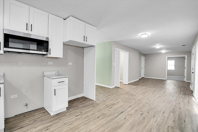 549 Allen Ln, University Park, IL 60484 - kitchen featuring stainless steel microwave, open floor plan, white cabinetry, and light wood-style flooring