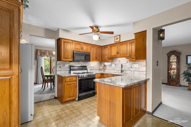 6841 Carpenter St, Downers Grove, IL 60516 - kitchen featuring range with gas stovetop, black microwave, freestanding refrigerator, light flooring, and brown cabinets