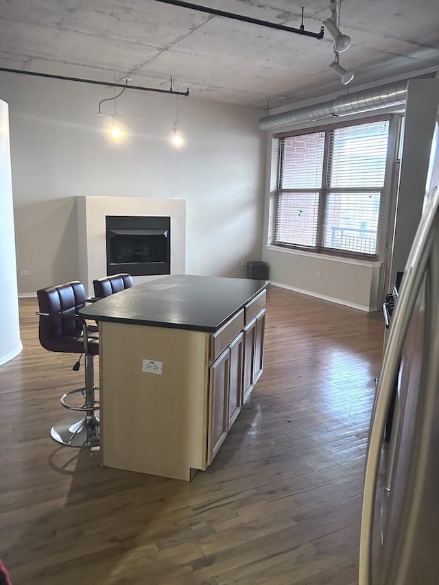 6 S Laflin St Unit 920, Chicago, IL 60607 - kitchen with dark countertops, dark wood-style flooring, a kitchen island, a breakfast bar, and open floor plan