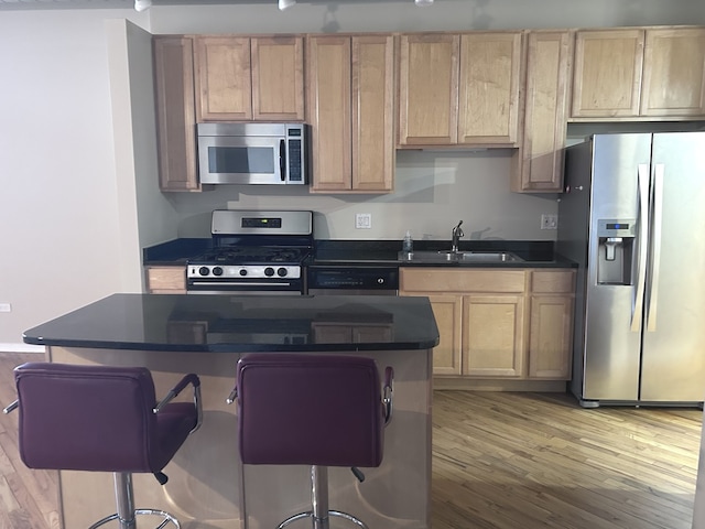 6 S Laflin St Unit 920, Chicago, IL 60607 - kitchen featuring stainless steel appliances, dark countertops, light wood finished floors, a center island, and a kitchen breakfast bar