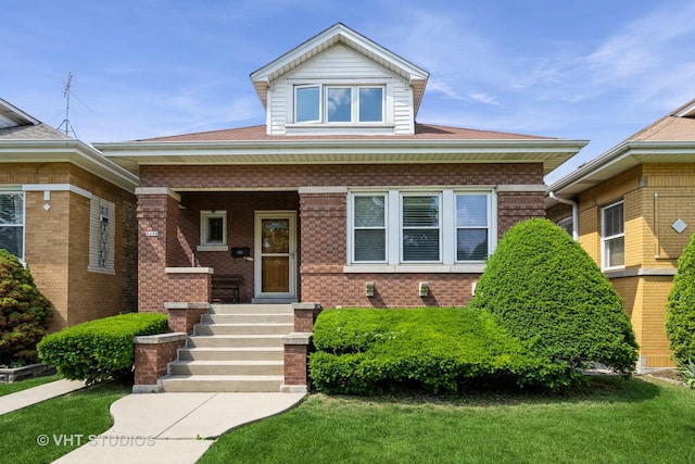 5404 W Henderson St, Chicago, IL 60641 - view of front of home with covered porch, brick siding, and a front lawn