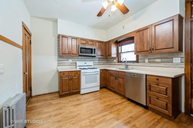 5404 W Henderson St, Chicago, IL 60641 - kitchen with appliances with stainless steel finishes, radiator heating unit, ceiling fan, and backsplash